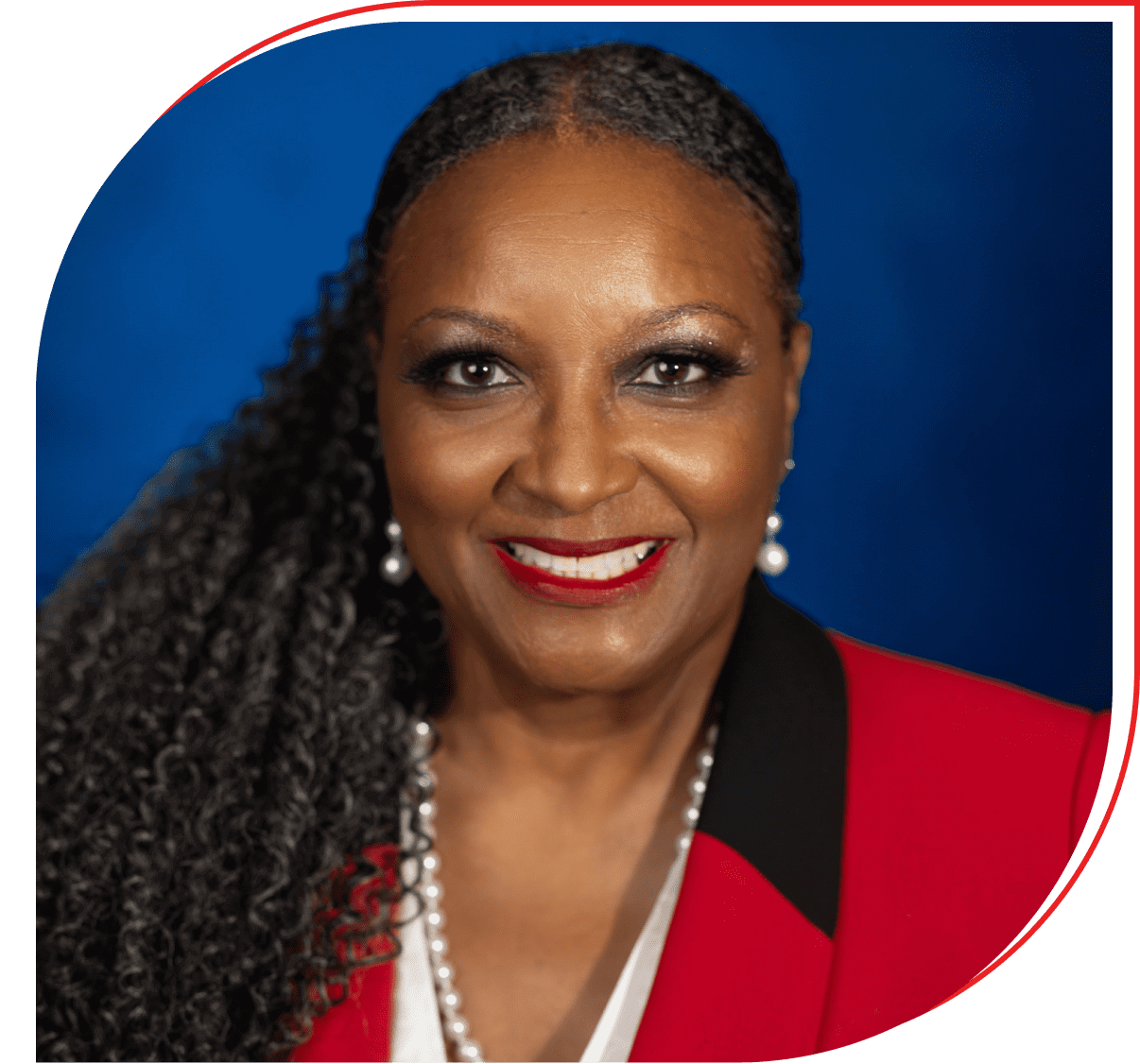 Professional woman with braided hair and a red outfit smiling warmly.